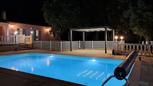Una piscina con zona techada y valla.