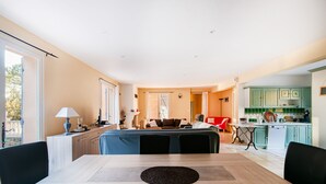 Una sala de estar moderna con comedor, cocina y un dormitorio.