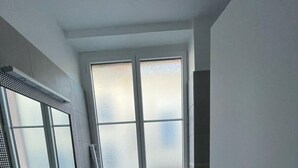 A modern bathroom with two sinks, a large mirror, frosted windows, and a door leading to a balcony. - Appartio - Large house near PARIS (Villiers-le-Bel)