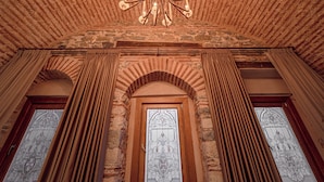 A room with a stone ceiling, a chandelier, and a door with stained glass. - Stone Inn Galata (Istanbul)