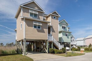 A multi-story residential building with a central staircase, a porch, and a small deck area. - Coastal Dream - Soundfront House, 3 BR, 2.5BA at Atlantic Beach! (Atlantic Beach)