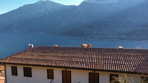 Un edificio con techo de tejas que da vistas a un lago y montañas.