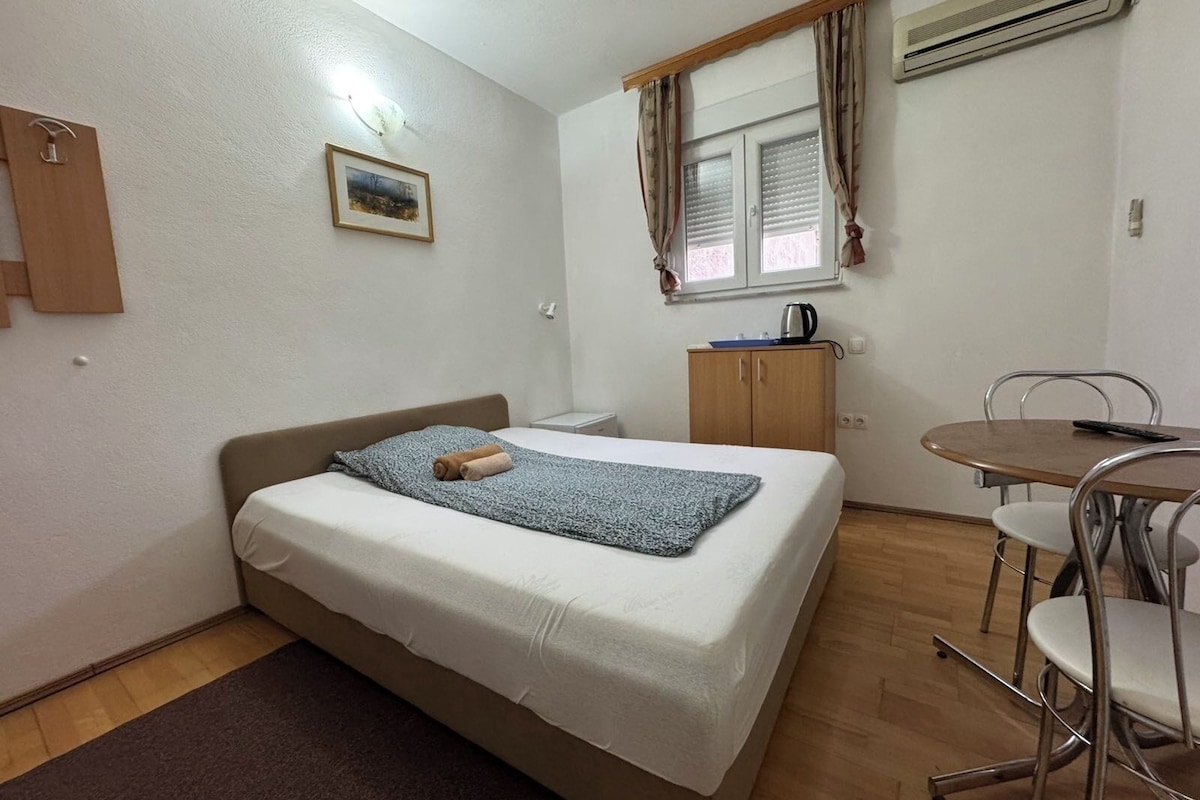 A small, tidy room with a bed, a desk, and a chair.