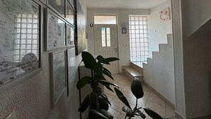 A hallway with a staircase, a door, and a plant. - Villa Anja Apartments (Mostar)
