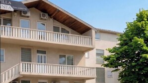 A multi-story building with balconies, air conditioning units, and a sign indicating it is a hotel. - Villa Anja Apartments (Mostar)