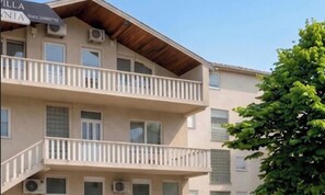 A multi-story building with balconies, air conditioning units, and a sign indicating it is a hotel. - Villa Anja Apartments (Mostar)