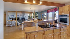 Una cocina moderna con armarios de madera, encimera de granito y estufa empotrada.
