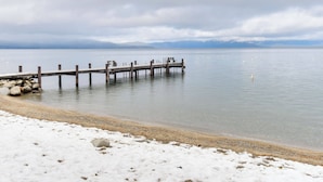 A wooden pier extending into calm waters with a snowy beach in the foreground. - Waters Edge Escape | Patio w/ BBQ, Near Beach (Tahoma)