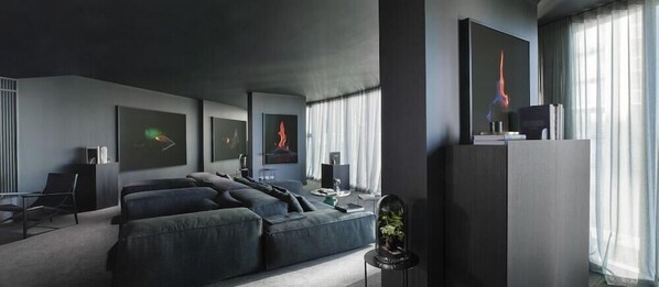Una sala de estar moderna con un sofá modular, un televisor de pantalla plana y obras de arte en las paredes.