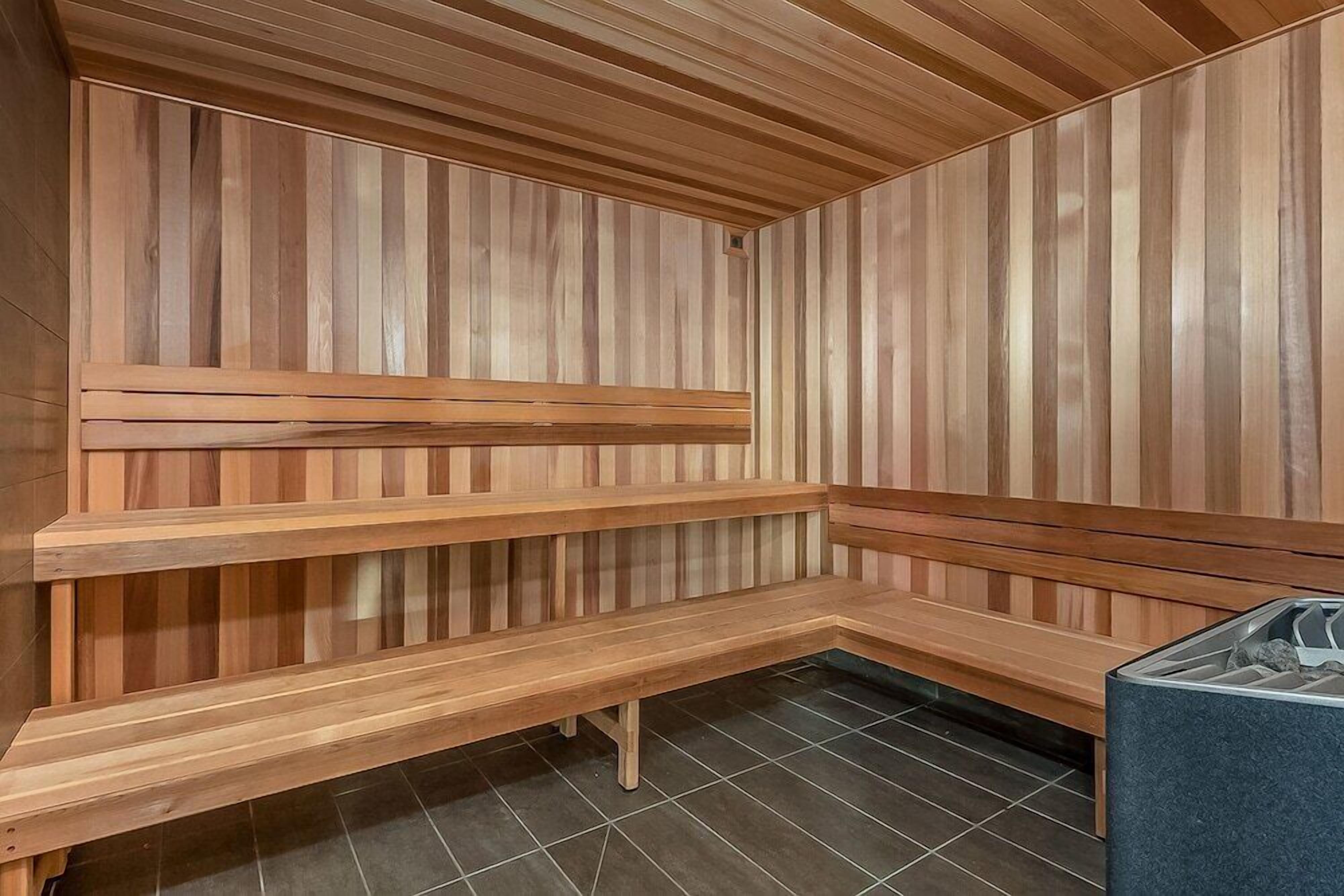 A sauna with wooden benches and a tiled floor.