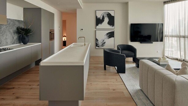 Un espacio moderno para vivir con una isla de cocina, zona de estar y televisor de pantalla plana.