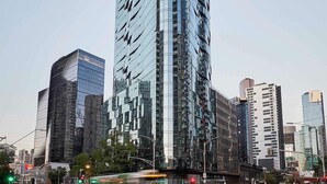 Un paisaje urbano con modernos rascacielos, una intersección concurrida y un cielo despejado.