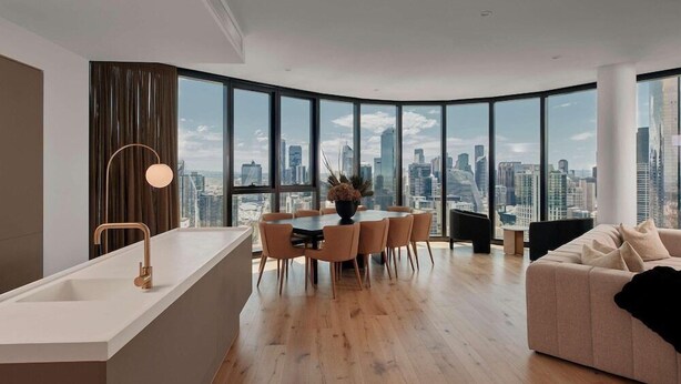 Un interior moderno con zona de comedor, sofá y vistas a la ciudad.