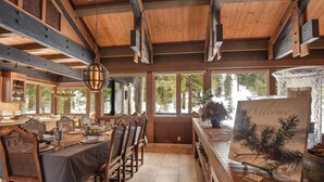 A dining area with a long table, wooden chairs, and a 'Welcome' sign.