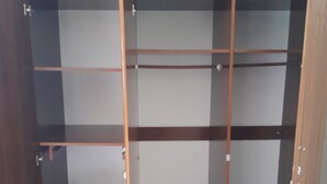 A wooden wardrobe with multiple shelves and a door. - anna's homestay (Arusha)