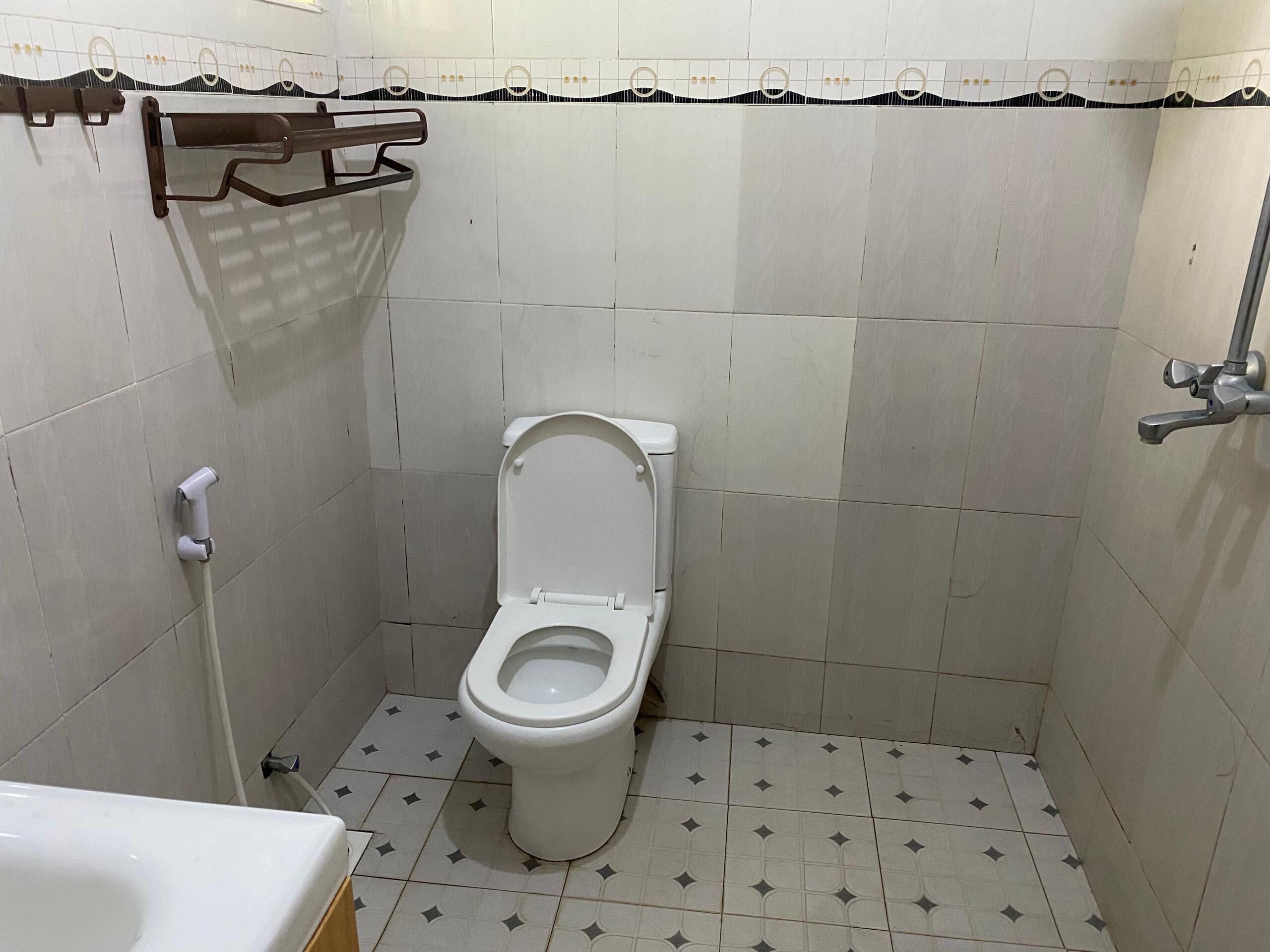Ein kleines, sauberes Badezimmer mit Toilette, Dusche und Waschbecken.