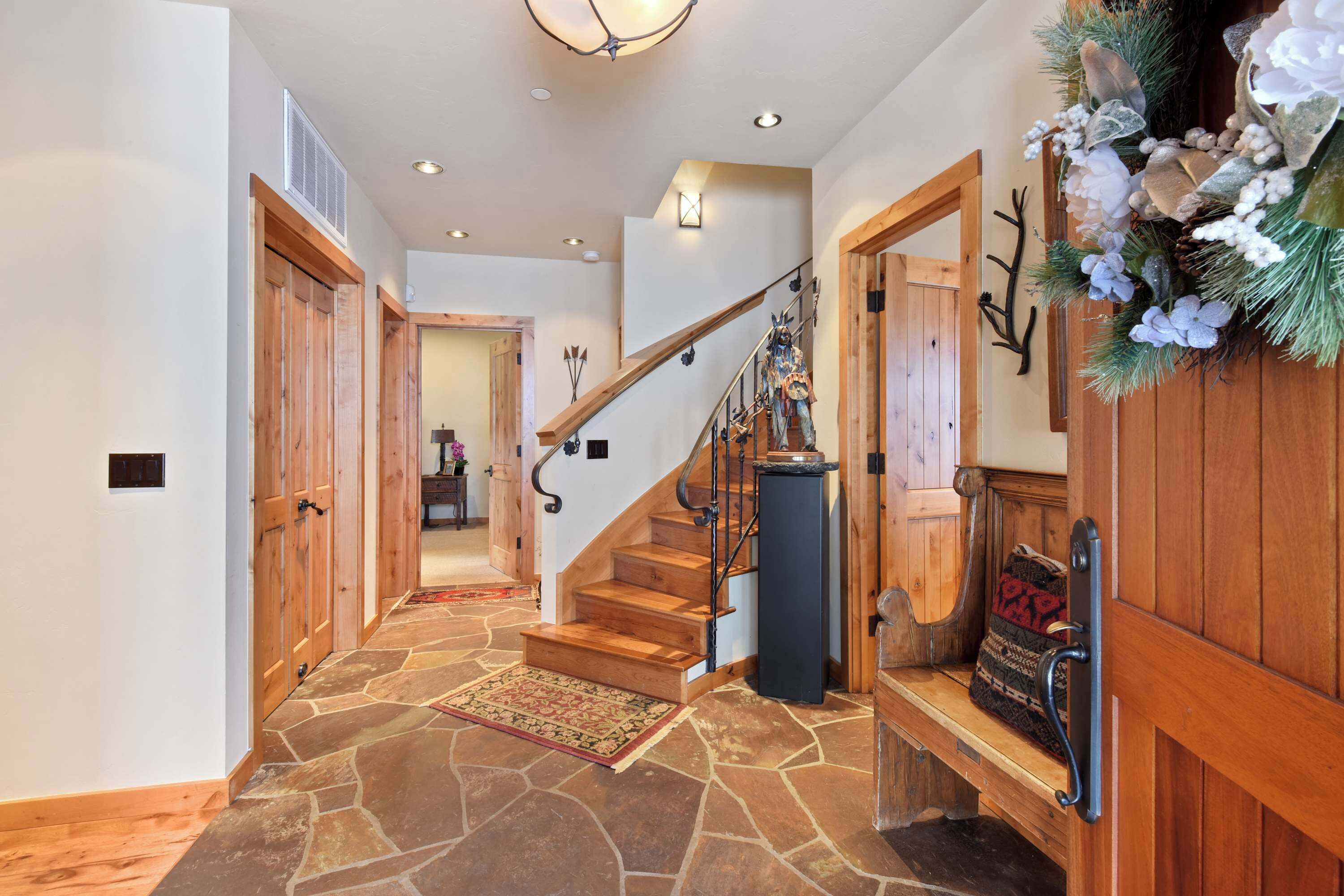 A wooden staircase with a stone floor leading to a second floor.