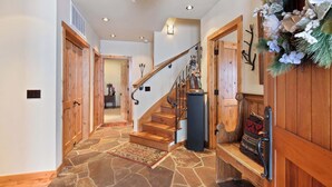 A wooden staircase with a stone floor leading to a second floor.