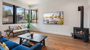 Una sala de estar moderna con sofá, mesa de centro y chimenea.