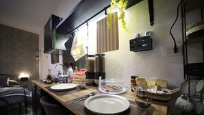 A dining area with a wooden table set for two, a basket of bread, and a glass of water. - Cozy apartment in the heart of Palermo, Capo district, pets allowed (Palermo)