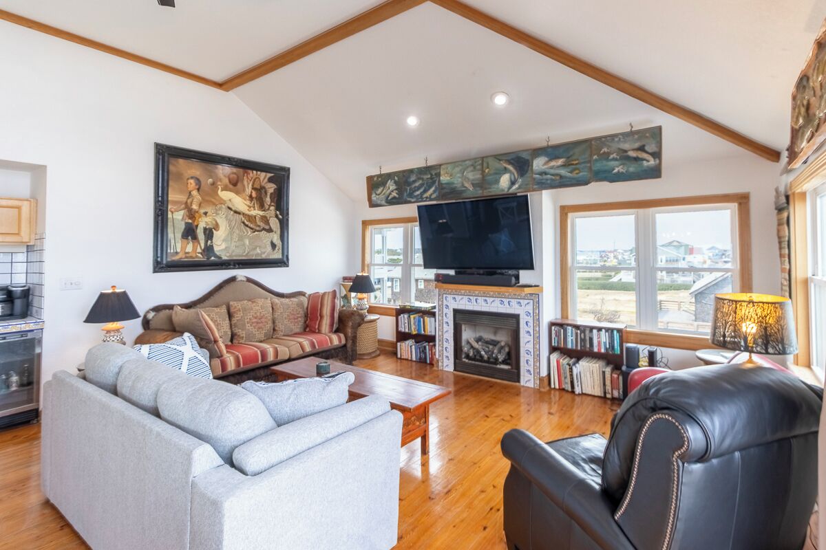 A spacious living room with a fireplace, a large flat-screen TV, and a comfortable seating area.