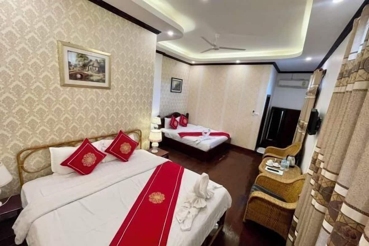 A hotel room with a bed, a chair, a television, and a wall-mounted picture.