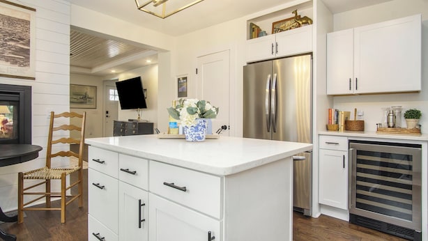 A modern kitchen with white cabinetry, a central island, a stainless steel refrigerator, and a built-in wine cooler. - Fabulous, 4 Bedroom, 3 Bathroom home in Downtown Ludington (Ludington)