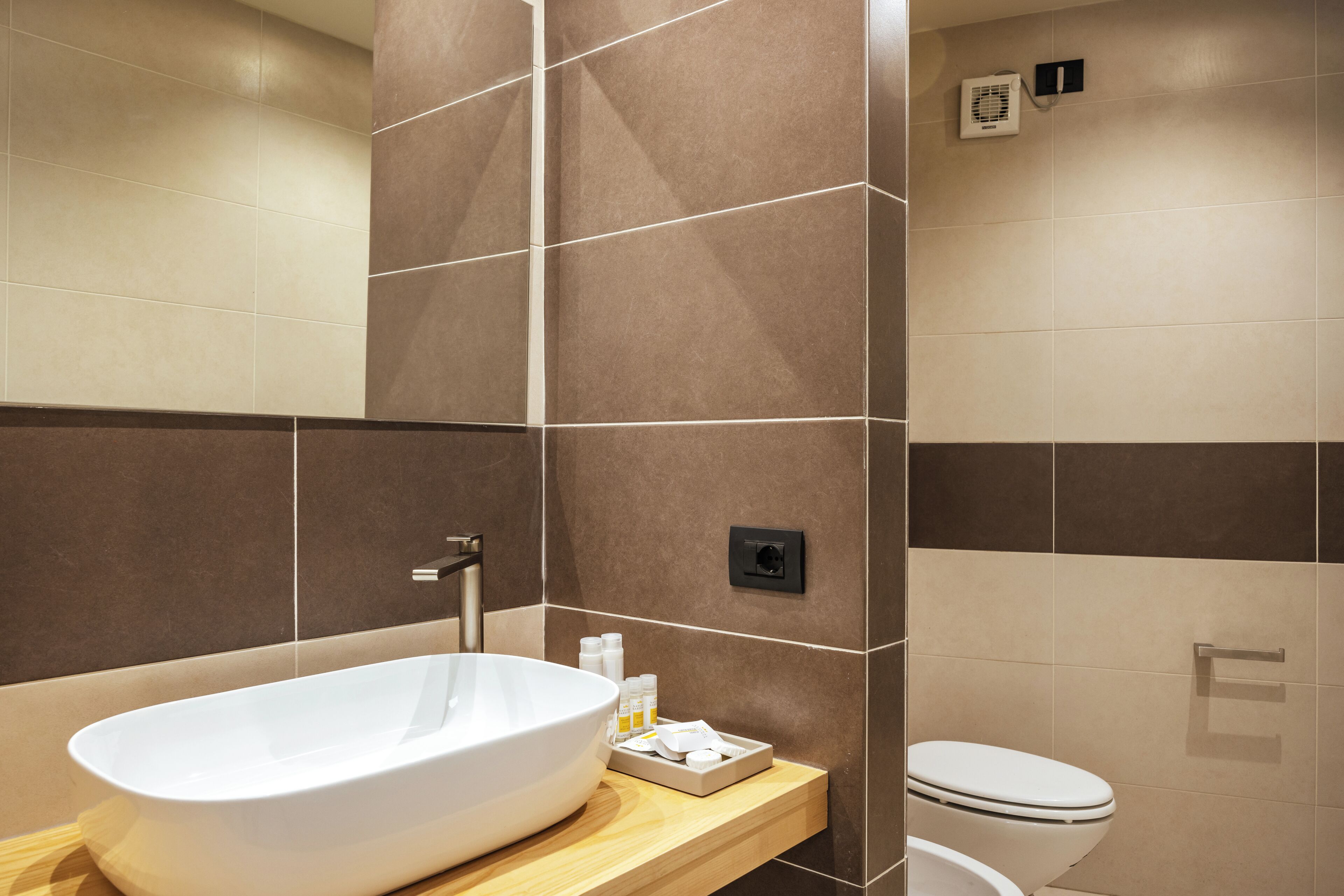 Un baño moderno con una bañera independiente, inodoro y un perchero para toallas.