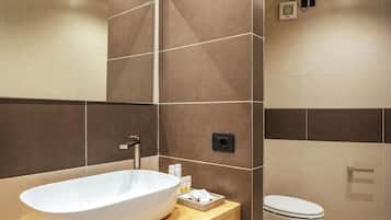 Un baño moderno con una bañera independiente, inodoro y un perchero para toallas.