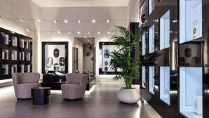 Een moderne lobby met een receptiebalie, een zithoek en wanddisplays.