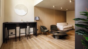 A modern living room with a dining area, a sofa, a coffee table, and a lamp.