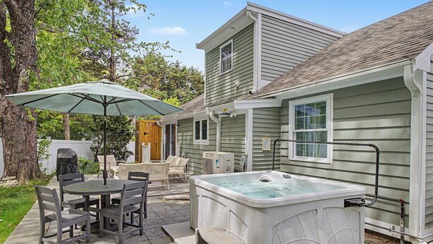 A patio with a hot tub, outdoor furniture, and a covered table. - 6 Richards Way (Sandwich)