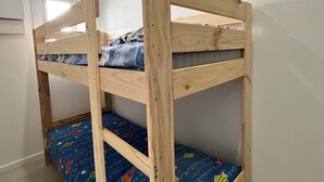 Ein Etagenbett mit blauer Matratze, verziert mit einem Muster aus Früchten und Gemüse.