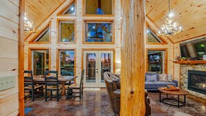 A log cabin interior with a dining area, living room, and fireplace. - 8 BR sleeps 29 river front *private island* pool tables (Smithville)