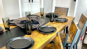 A dining table set with black plates, glasses, and a wire basket. - 12 Minutes from Crossbar and Turner Falls, Sleeps up to 10, Fast Wi-Fi (Davis)