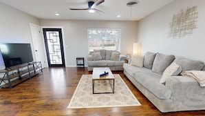 A living room with a grey sofa, a coffee table, a TV, and a patterned rug. - 12 Minutes from Crossbar and Turner Falls, Sleeps up to 10, Fast Wi-Fi (Davis)