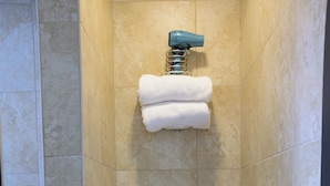Une petite salle de bain moderne équipée de toilettes, d’une douche et d’un porte-serviettes.