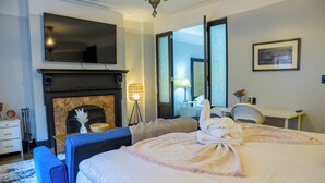 Une chambre d’hôtel équipée d’un lit, d’un téléviseur à écran plat, d’une cheminée, d’un bureau et d’une chaise.