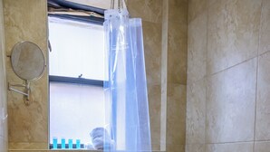 Une salle de bain avec une baignoire, un lavabo et une fenêtre donnant sur l’extérieur.