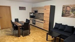 Un espacio habitable compacto con comedor, kitchenette y sofá.