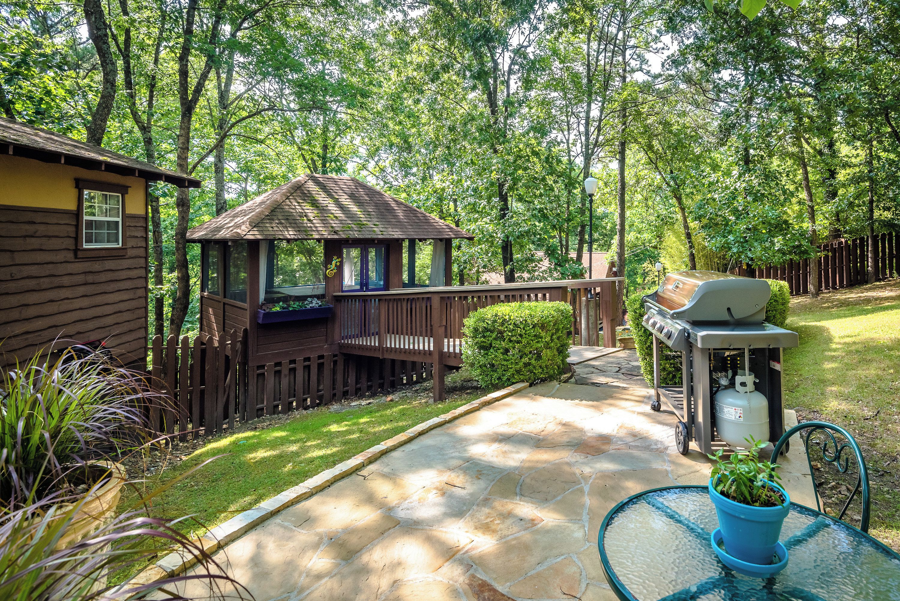A wooden deck with a barbecue grill and a small gazebo.