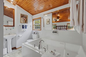 A modern bathroom with a freestanding bathtub, a vanity with a sink, and a toilet. - Stunning 2 Bedroom Cabin In The Woods, Covered Porch, Jacuzzi, Kitchen & Hot Tub (Eureka Springs)