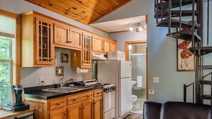 A kitchen with wooden cabinets, a stove, a refrigerator, and a microwave. - Stunning 2 Bedroom Cabin In The Woods, Covered Porch, Jacuzzi, Kitchen & Hot Tub (Eureka Springs)