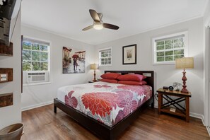 A bedroom with a bed, a ceiling fan, a bedside table with a lamp, and a window. - 1 Bedroom Cabin In The Woods, Covered Porch, Jacuzzi, Kitchen & Hot Tub. (Eureka Springs)