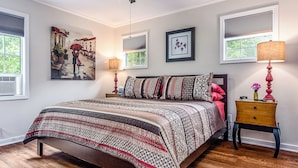 A bedroom with a bed, two bedside lamps, a nightstand, and a window with blinds. - 1 Bedroom Cabin In The Woods, Covered Porch, Jacuzzi, Kitchen & Hot Tub. (Eureka Springs)