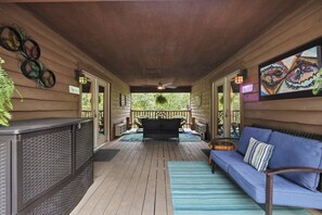A covered porch with a seating area, a bar, and a view of the outdoors. - 1 Bedroom Cabin In The Woods, Covered Porch, Jacuzzi, Kitchenette and Hot Tub. (Eureka Springs)
