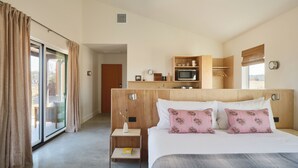 Et hotelværelse med en seng, et lille natbord, en mikrobølgeovn og udsigt til det fri.