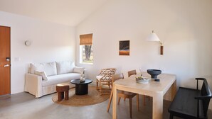 En moderne stue med sofa, sofabord, spisebord og stole.