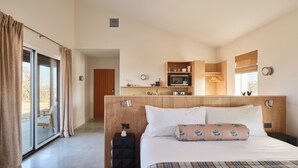 A hotel room with a large bed, a small kitchenette, a sliding glass door to the outside, and a view of the outdoors. - Luxury cabin in the center of the Texas Wine Country; large private porch w/hot tub, gas grill and fire pit; pet friendly (Stonewall)