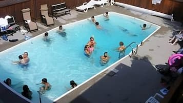 Ein Pool, umgeben von Liegestühlen und einer Holzterrasse.